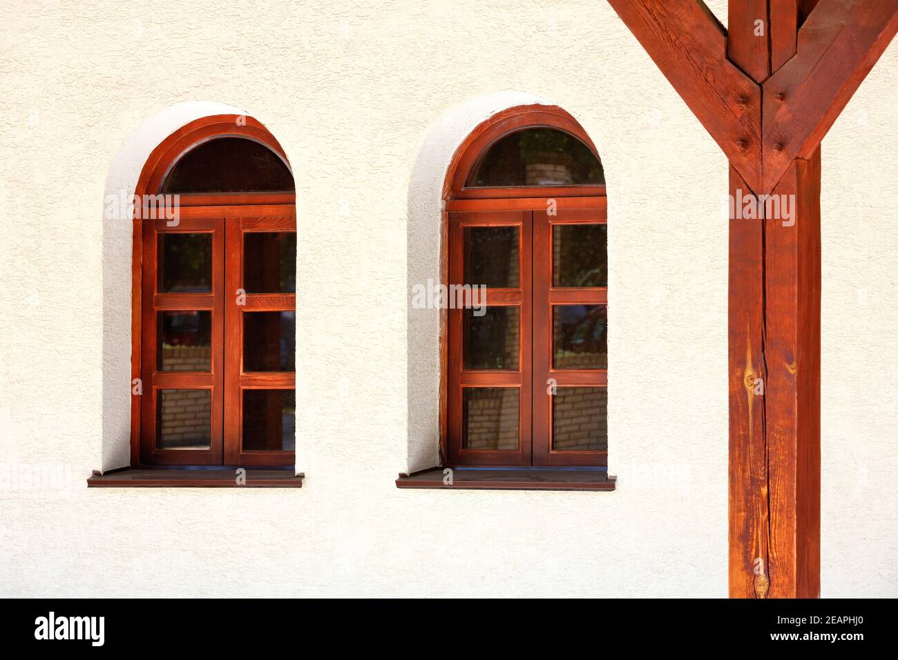 View of the terrace of an old Ukrainian rural hut with antique arched windows and a wooden support post. Stock Photo