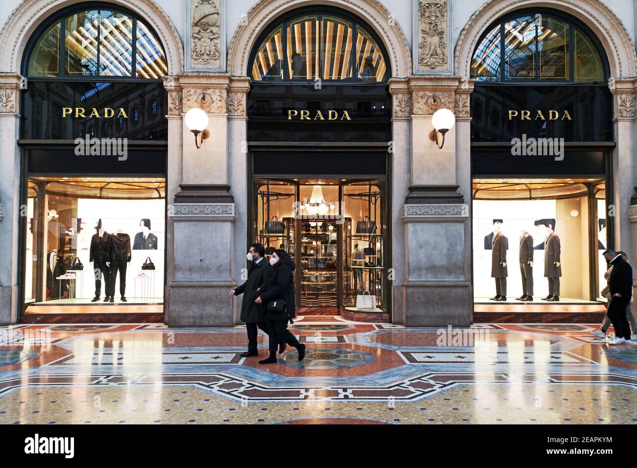 Couple walking in front of Prada boutique in Galleria Vittorio Emanuele II  in downtown Milan, Italy. People are wearing surgical masks Stock Photo -  Alamy