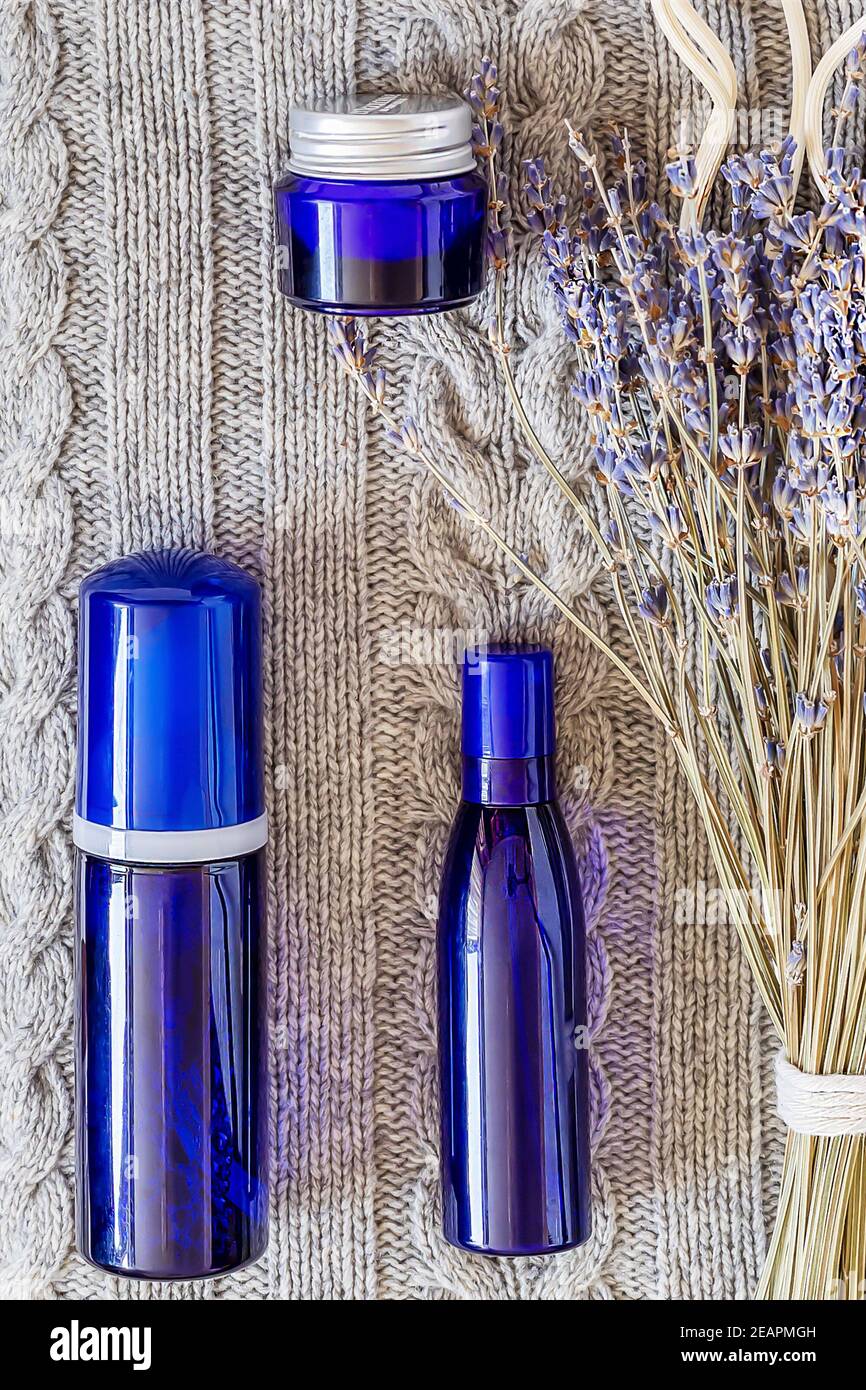 Mock up for cosmetics remedies for insomnia based on natural ingredients. Blue bottles with a bouquet of lavender on the cozy knitted blanket backgrou Stock Photo