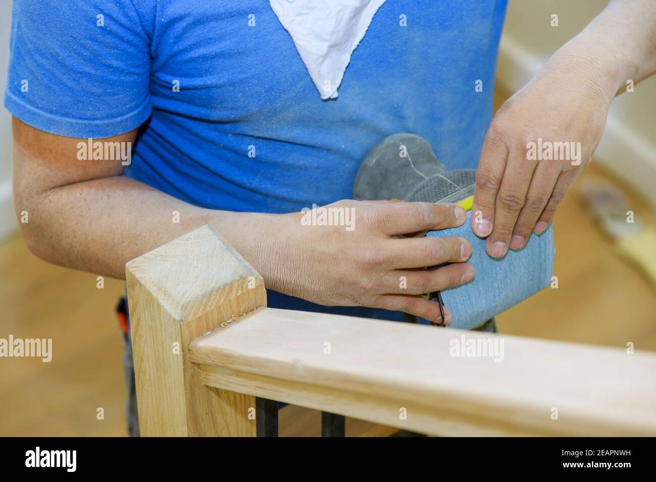 Wooden railing sanding with sandpaper for stairs grinder work in the timber wood Stock Photo