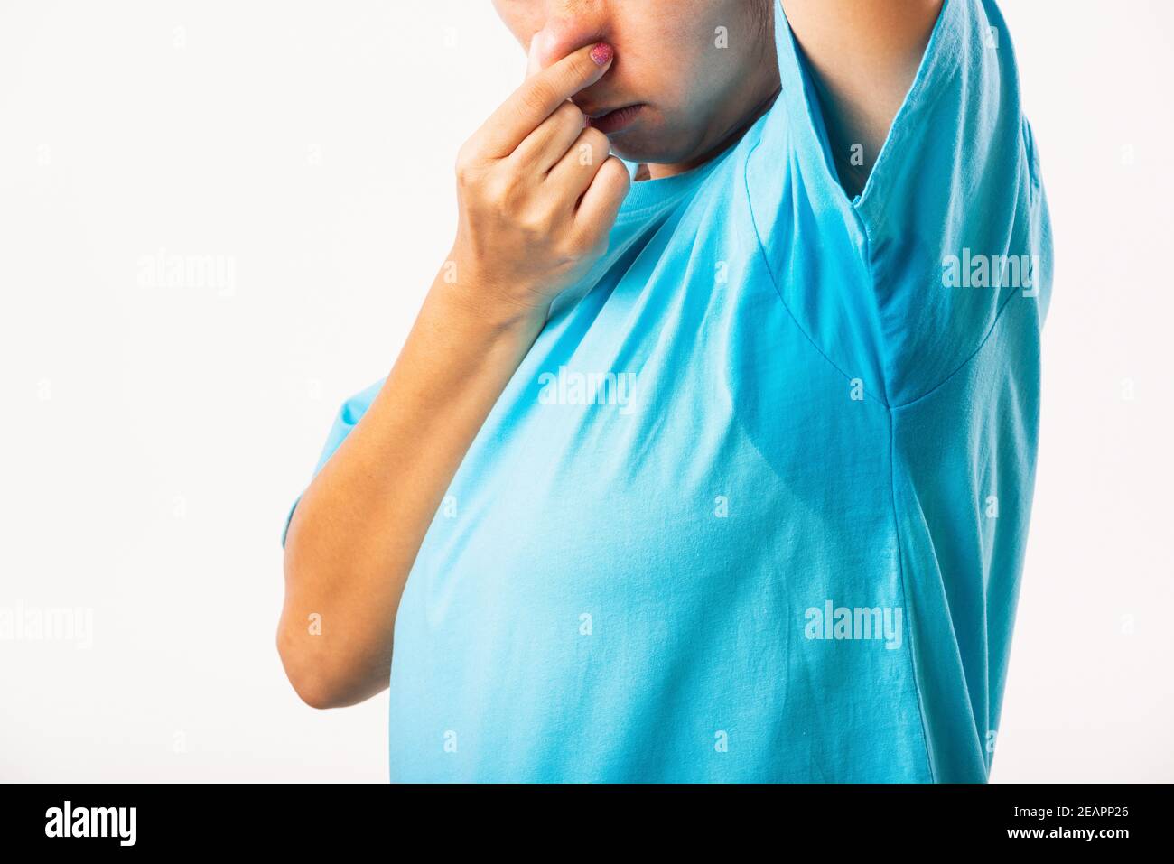 Female armpit sweat stain on her clothes smelly use hand close nose Stock Photo