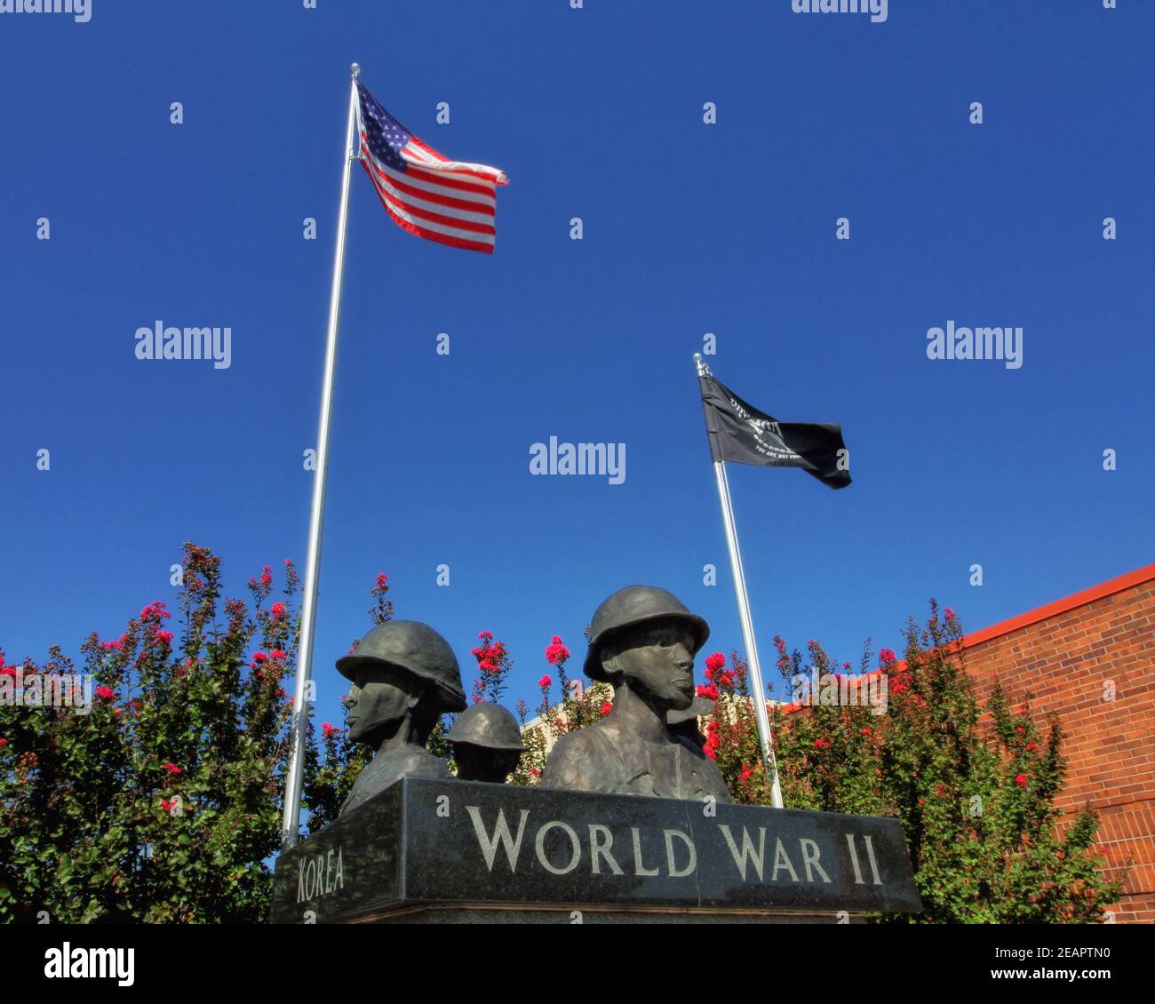 This view shows the top portion of the veterans memorial statue next to City Hall in downtown Tecumseh Oklahoma, with a black MIA and an American flag. Stock Photo