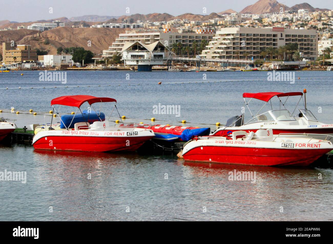 Small red and white rental boats float in Eilat Harbor, Israel's southernmost tip on the Red Sea. Stock Photo