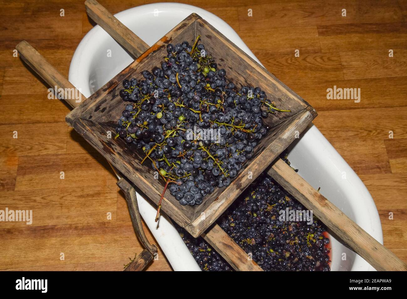 Manual mechanism for crushing grapes. Crush the grapes into juice and wine Stock Photo