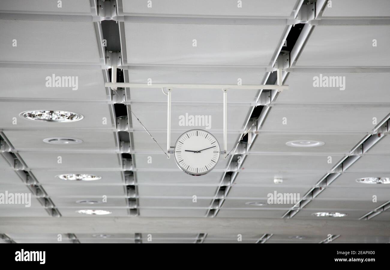 Hanging white clock at the big train station Stock Photo