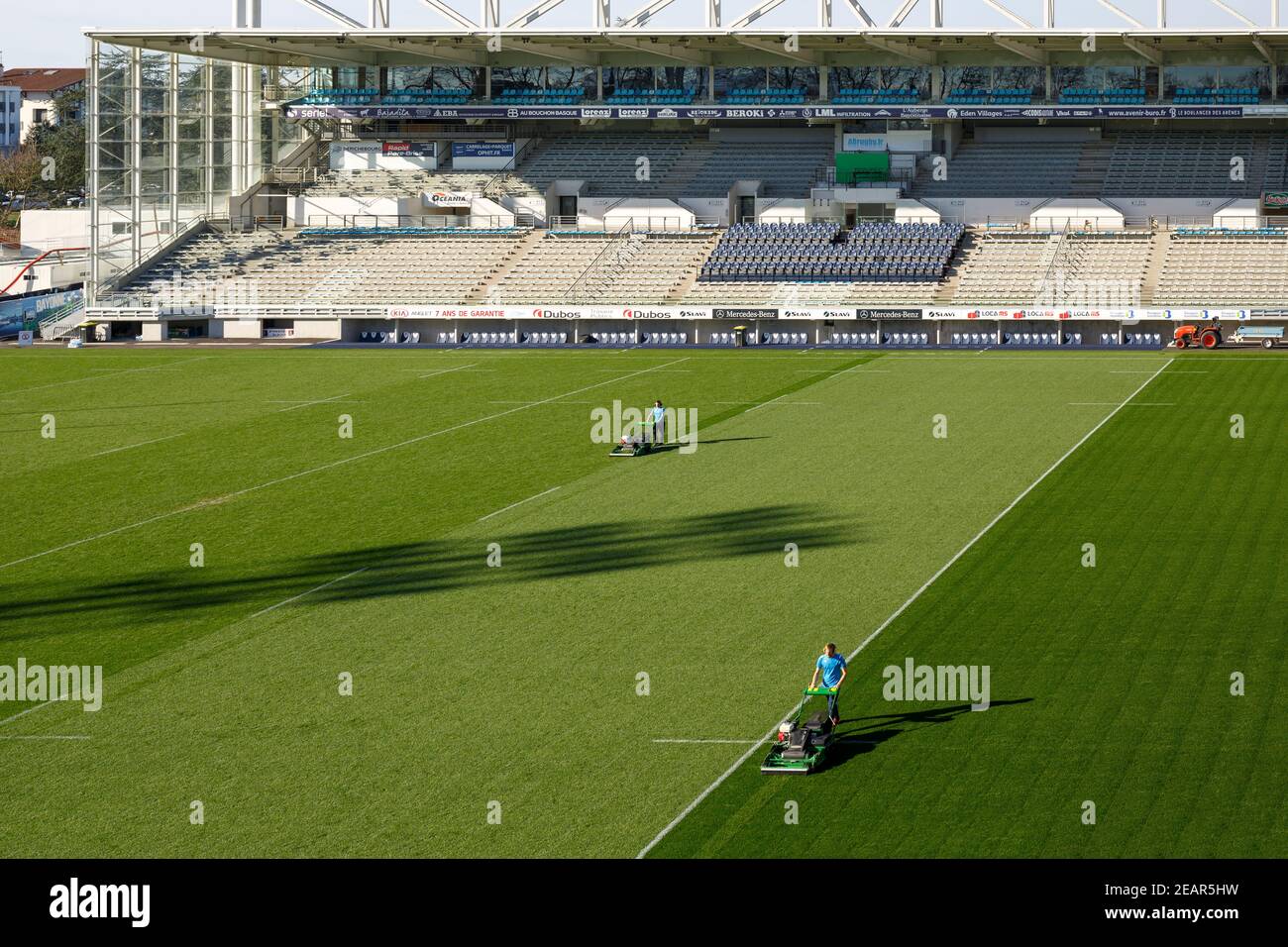 Two gardeners mowing the lawn of the Jean DAUGER stadium. Stock Photo