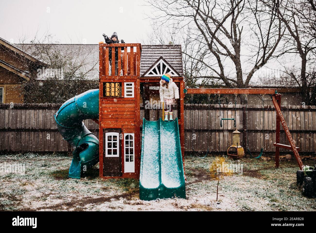 Young brother and sister standing in backyard playhouse in snow Stock ...