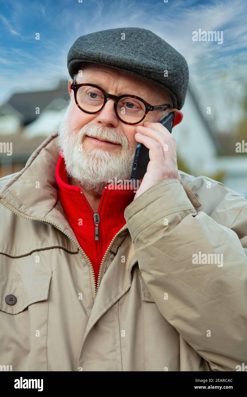 Senior using cellphone on his way home Stock Photo