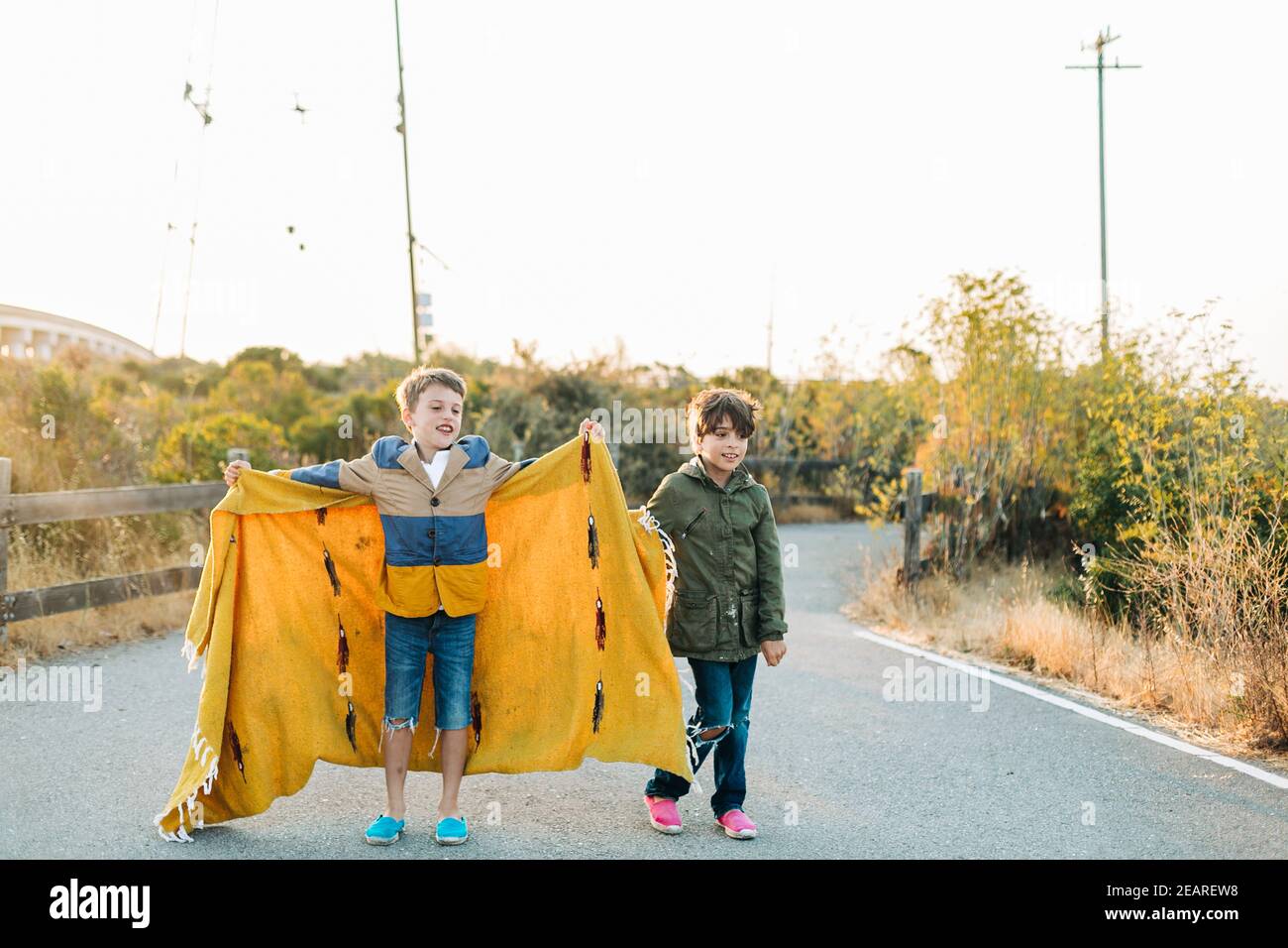 Pre-teens boys playing with yoga blanket in wildlife park at sunrise Stock Photo