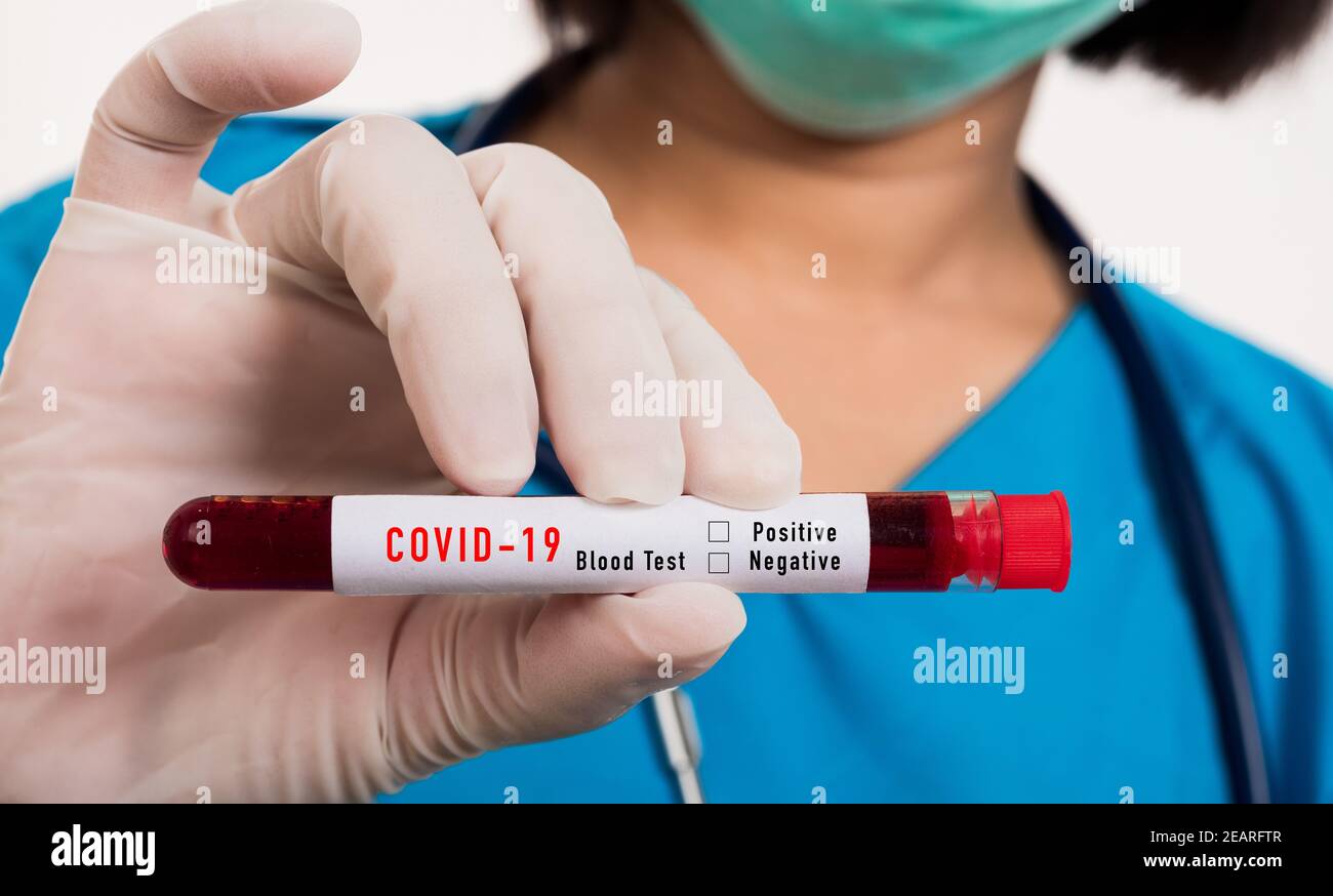 Nurse in blue uniform wear a mask holding test tube sample Coronavirus test blood Stock Photo