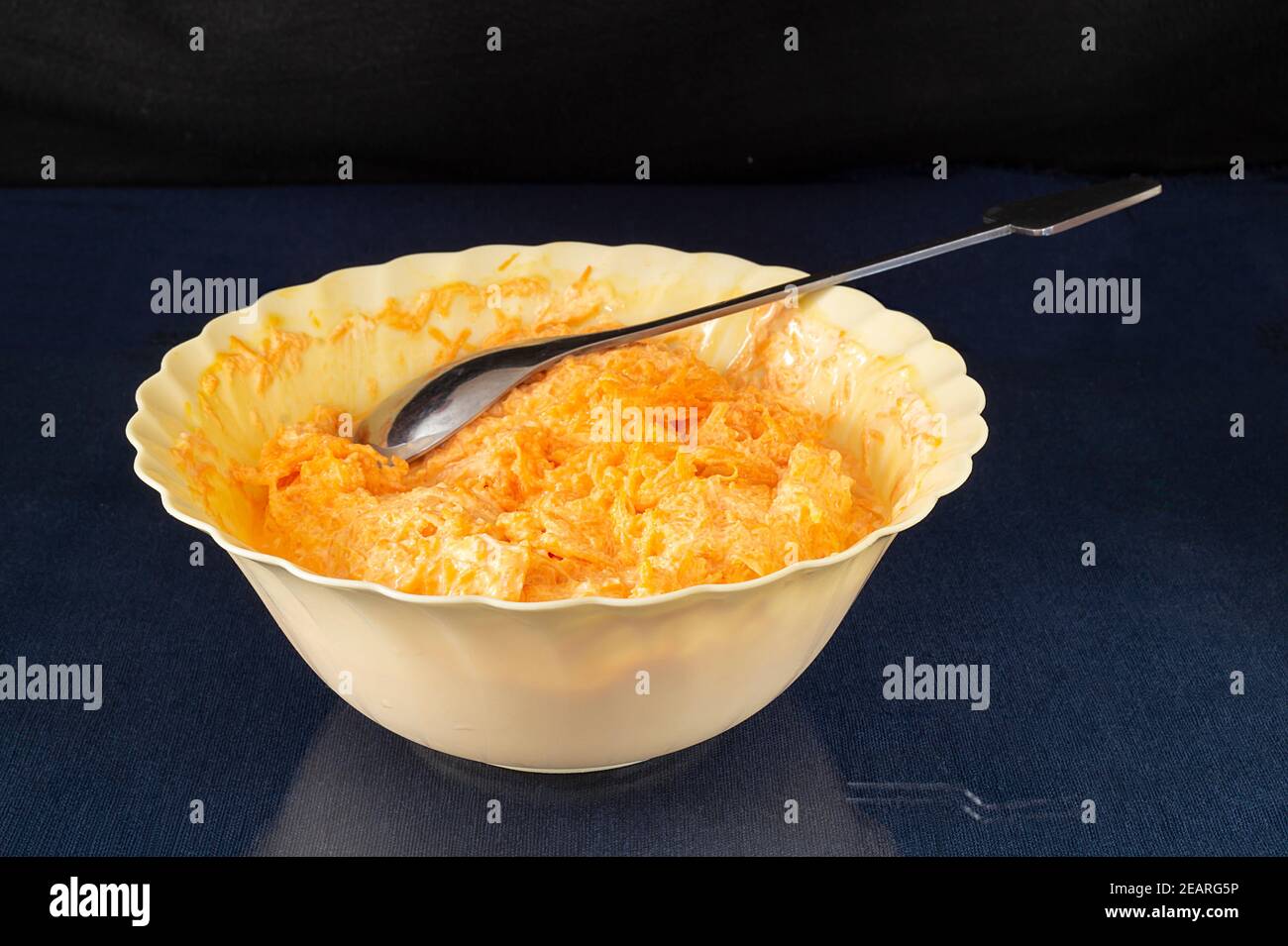 The Carrot with mayonnaise and garlic in plate on glass table. Products of the feeding on black background Stock Photo