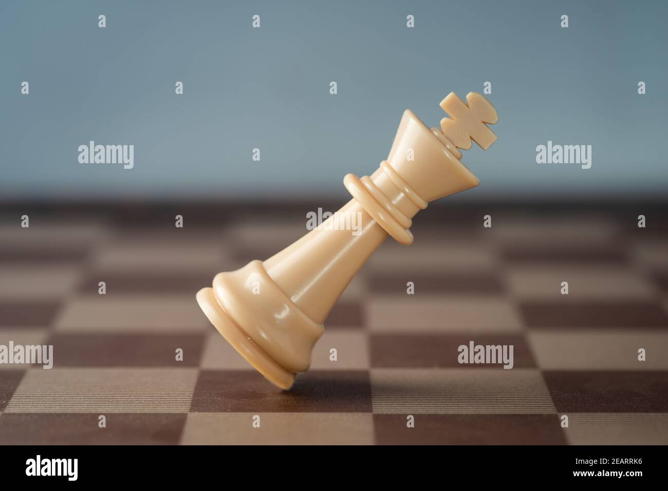 white chess king falling on chess board concept of failing. Stock Photo