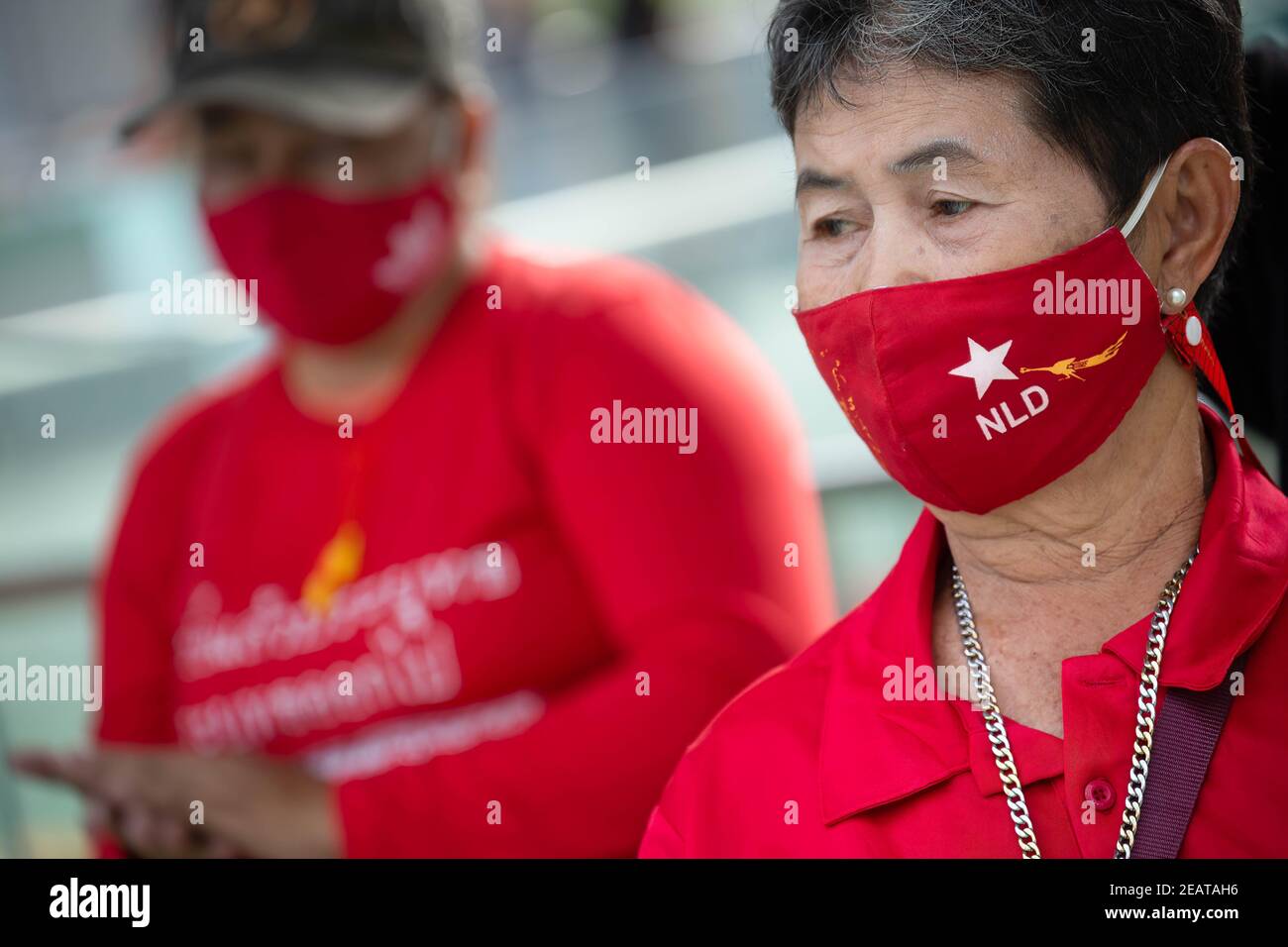 An elderly wearing an NLD (National League for Democracy) dances during a 'make noise' protest to denounce the recent junta military coup in Myanmar and reject Article 112 of the Thai penal code.Thousands of pro-democracy protesters staged a demonstration, outside of MBK Shopping Mall at Siam, called ‘Make Noise' by banging kitchen utensils in solidarity with the anti military coup protesters in Myanmar as well as rejecting the Section 112 of the Thai penal code. The protesters also demand the resignation of Thailand Prime Minister Prayut Chan-o-cha and the reform of the monarchy. Stock Photo