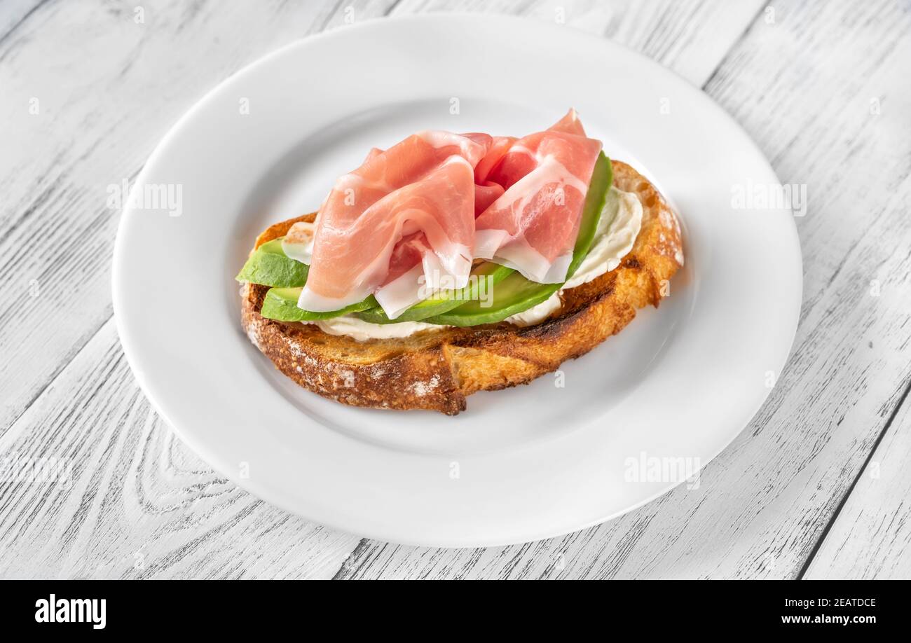 Toast with avocado, prosciutto and cream cheese Stock Photo Alamy