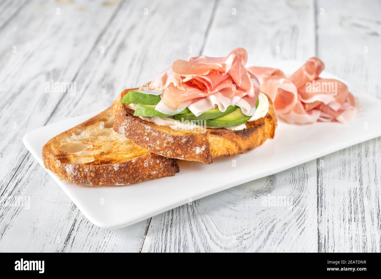 Toast with avocado, prosciutto and cream cheese Stock Photo Alamy
