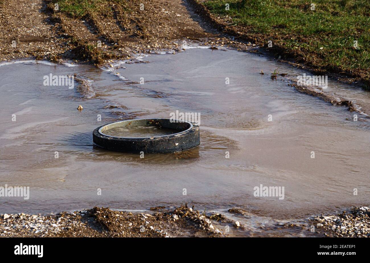 wheel from a British Army Warrior Infantry Fighting vehicle tank in a pool of frozen water, encased in ice Stock Photo