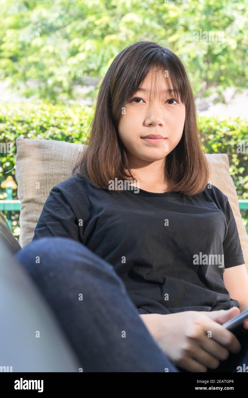 Young girl studying online from digital tablet in living room Stock Photo