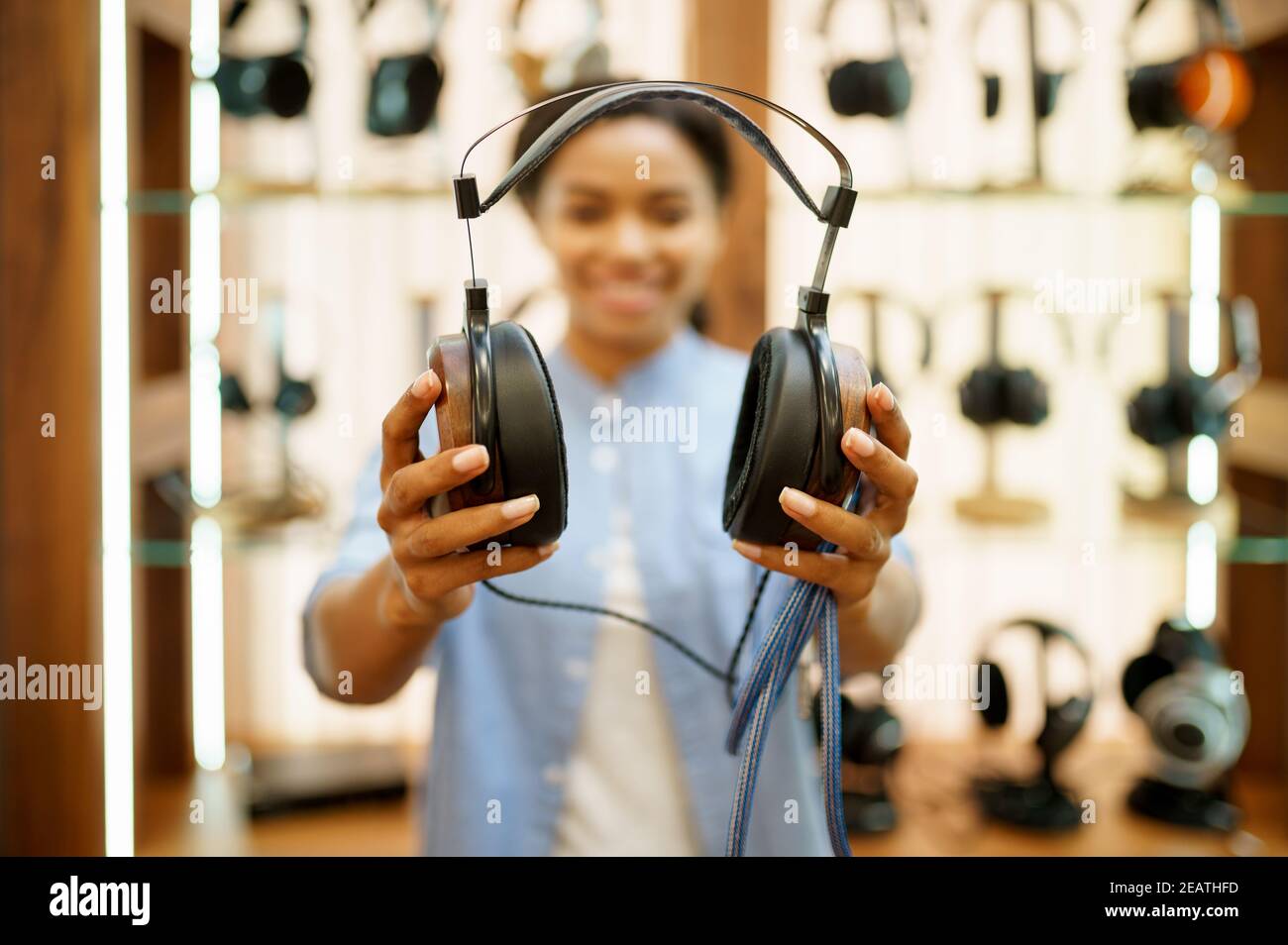 Woman shows headphones in audio components store Stock Photo Alamy