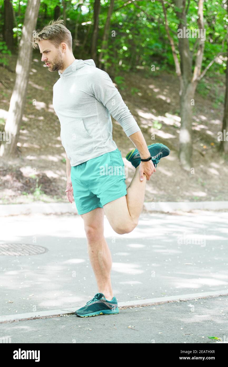 Athlete always stretching after workout. Sportsman prepare muscles outdoor training. Man runner confident face stretching leg muscles. Every runner should know reduce level injuries while running Stoc...