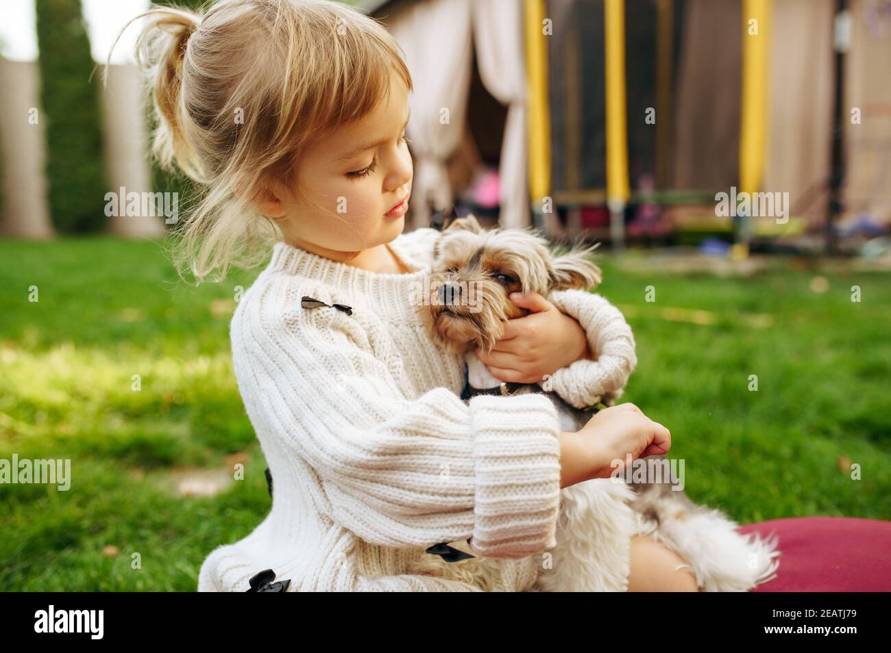 Kid embracing funny dog in the garden Stock Photo