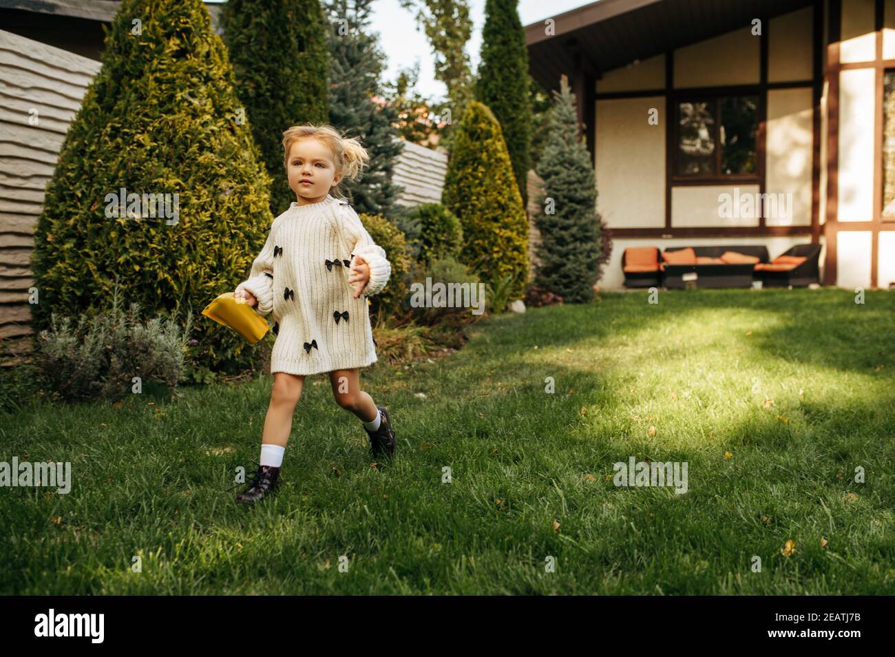 Little cheerful kid running in the garden Stock Photo