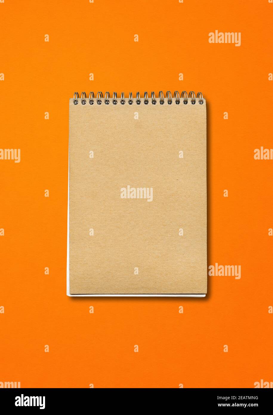 Spiral closed notebook mockup on orange background Stock Photo