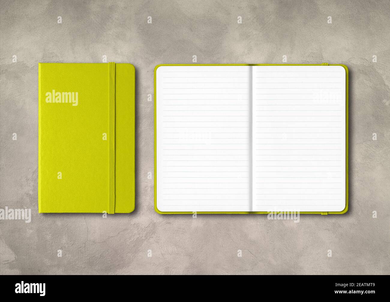 Lime green closed and open lined notebooks on concrete background Stock Photo