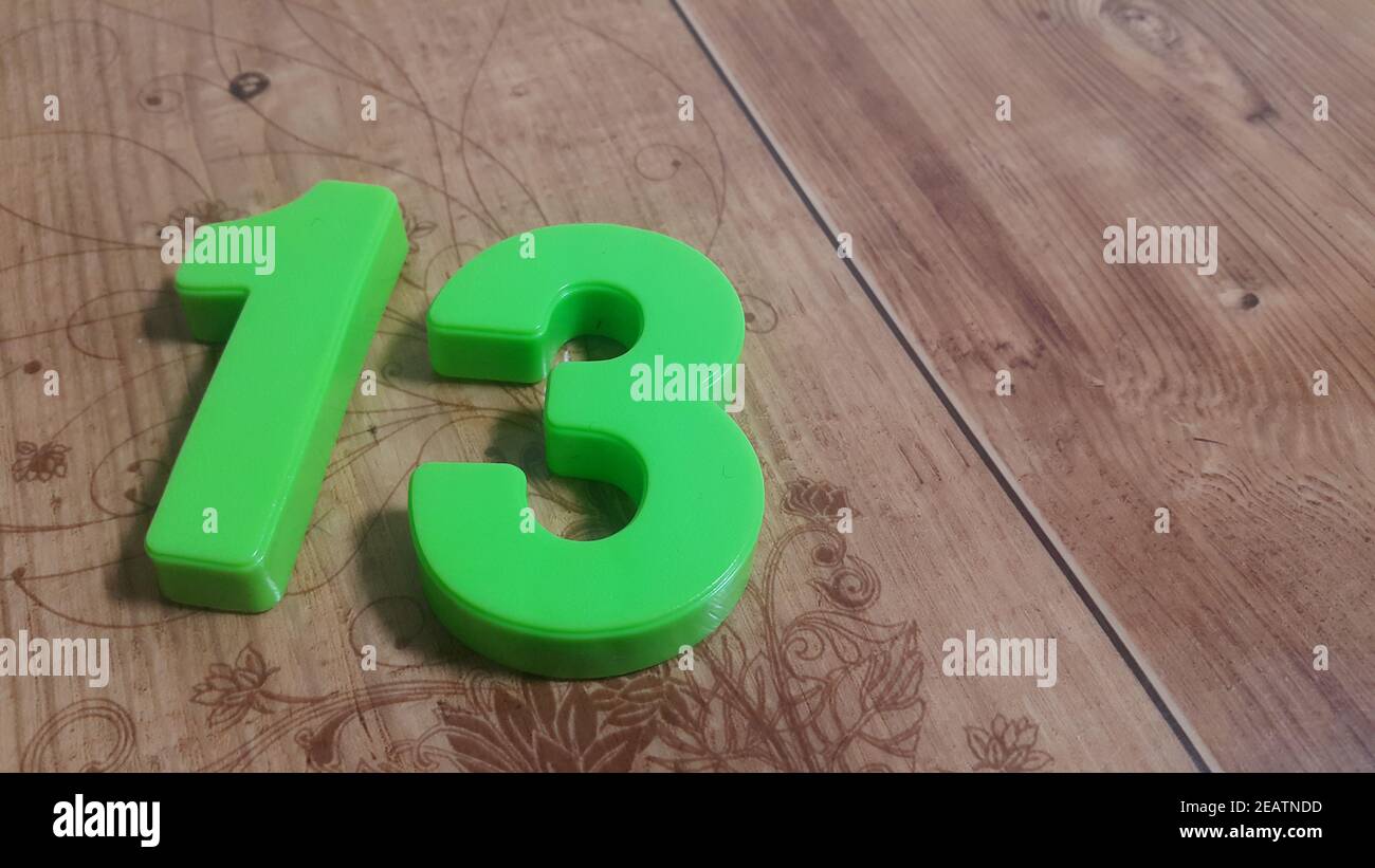 Plastic colored alphabets making words are placed on a wooden floor Stock Photo