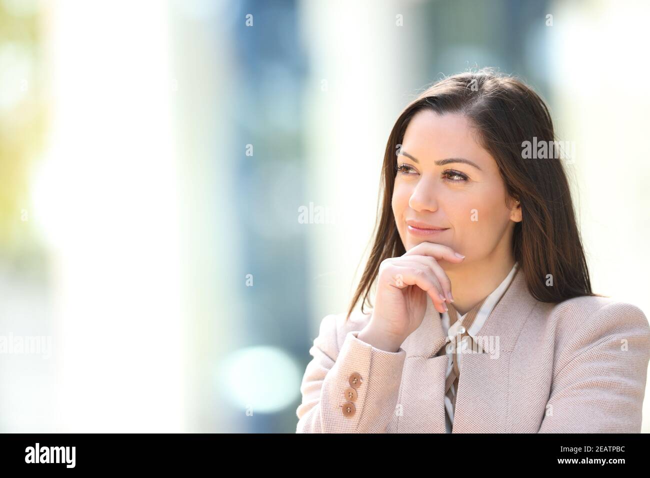 Businesswoman thinking looking at side outdoors Stock Photo