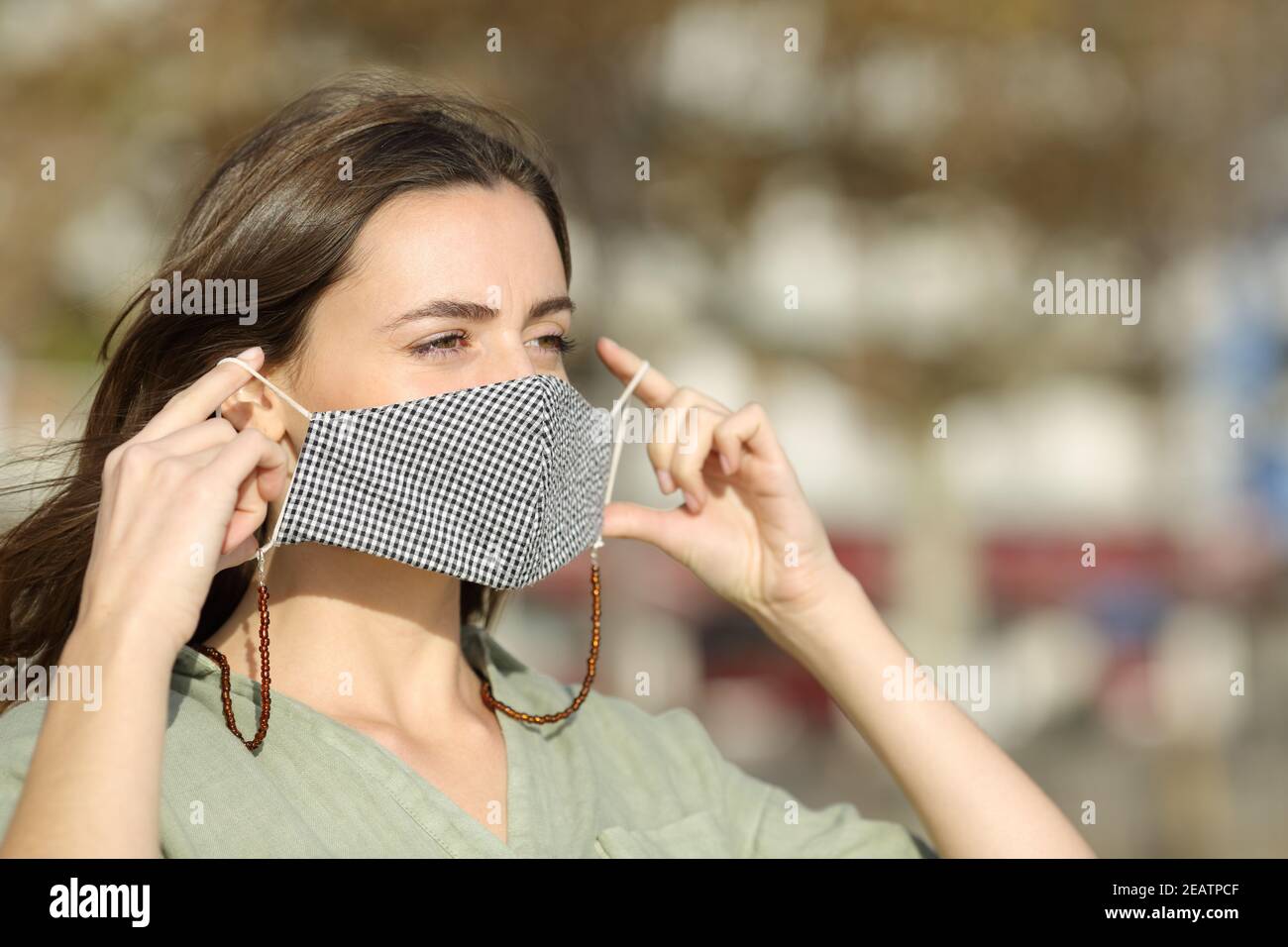 Woman putting mask due covid in the street Stock Photo