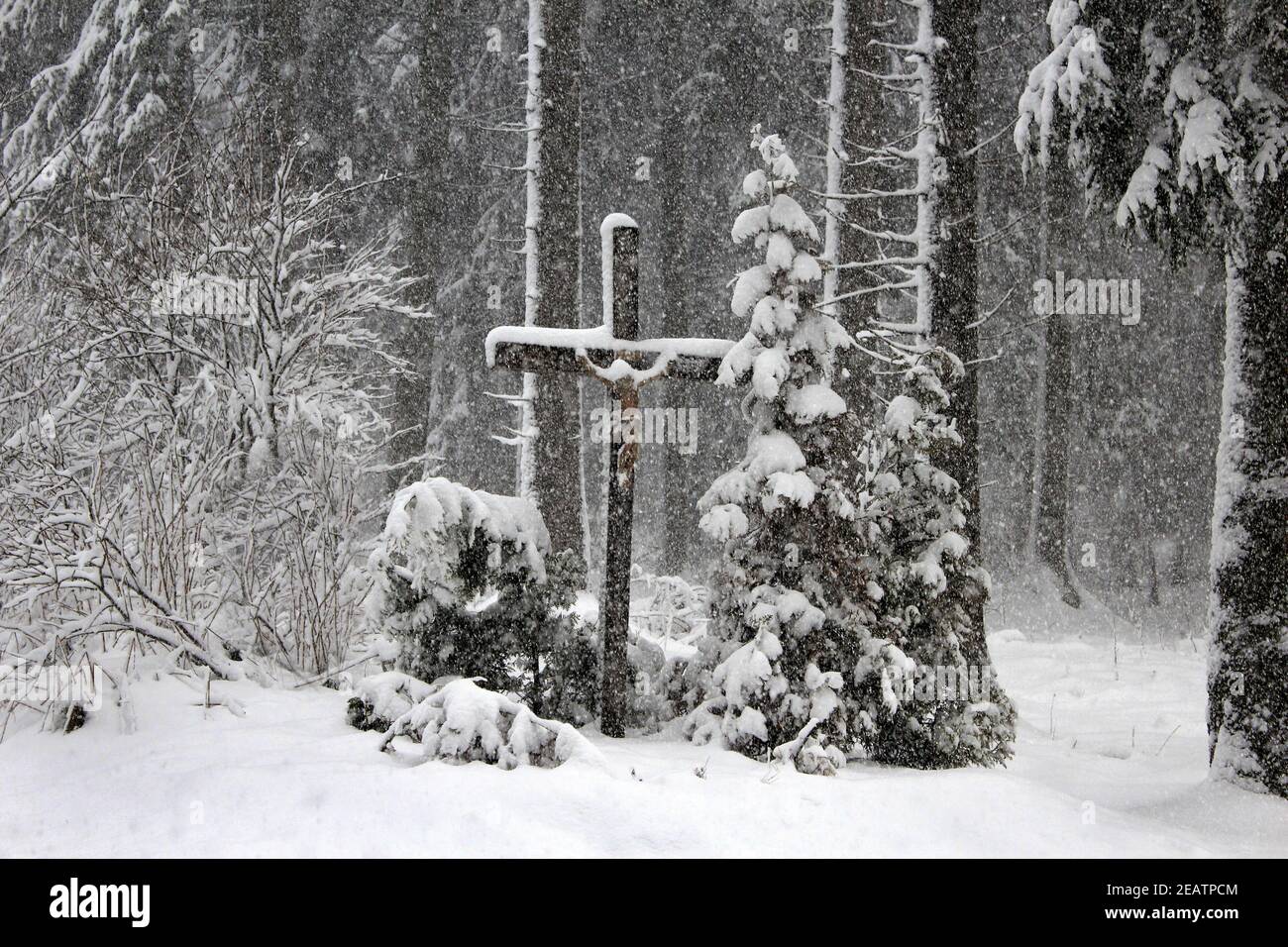 Christian cross and driving snow in winter forest Stock Photo