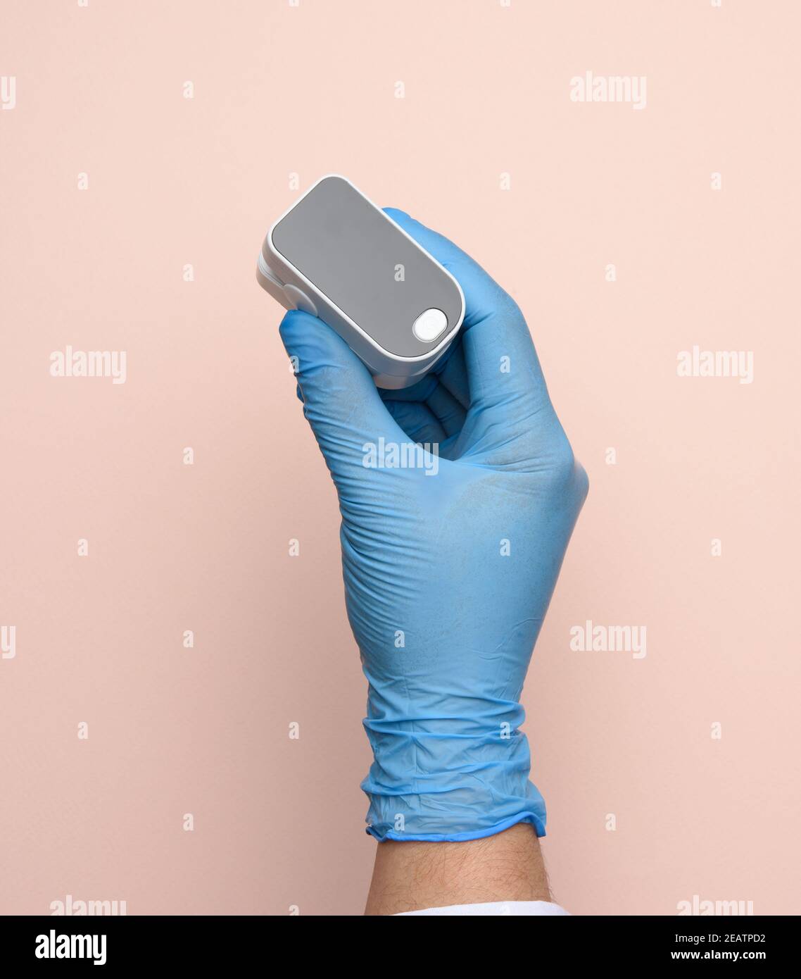 electronic pulse oximeter in the hands of a doctor, wearing blue latex gloves Stock Photo