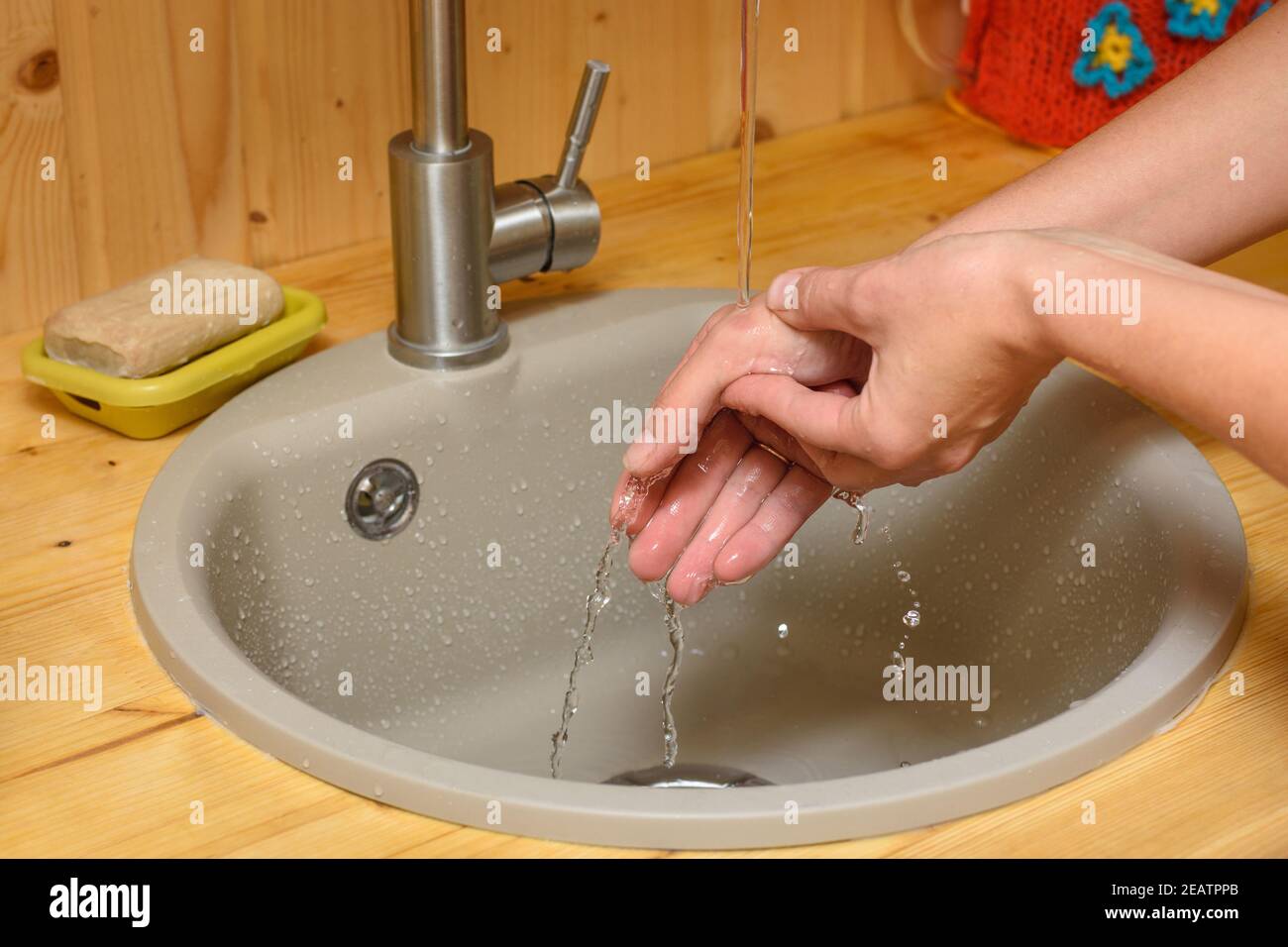 The girl's hands are washed with cold tap water the place of the burn on her arm Stock Photo