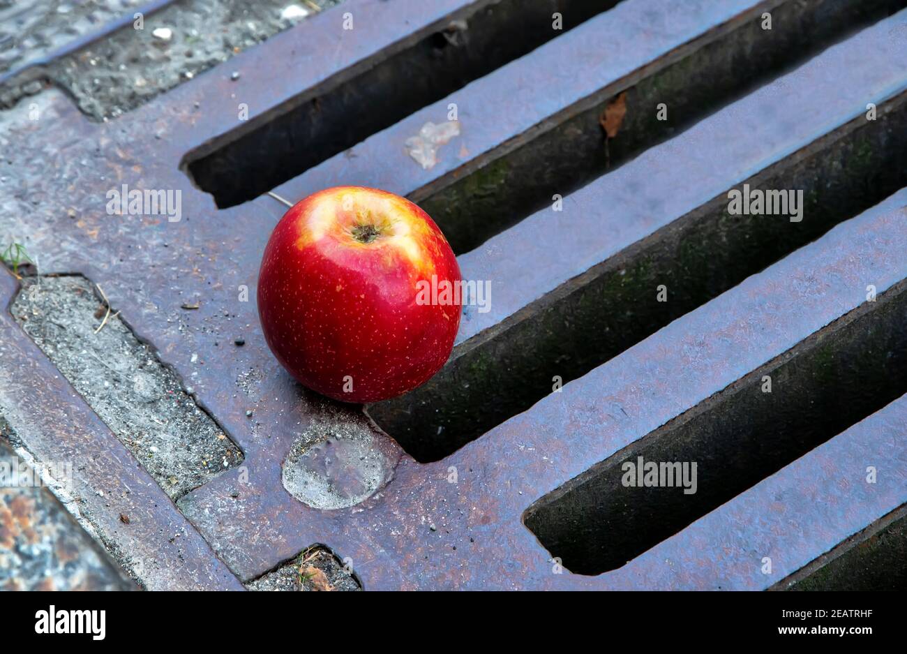 Healthy apple carelessly thrown away on the street Stock Photo