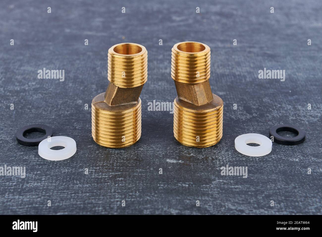 Brass eccentric connectors for the wall water mixer tap installation closeup on a gray background, shallow depth of sharpness Stock Photo