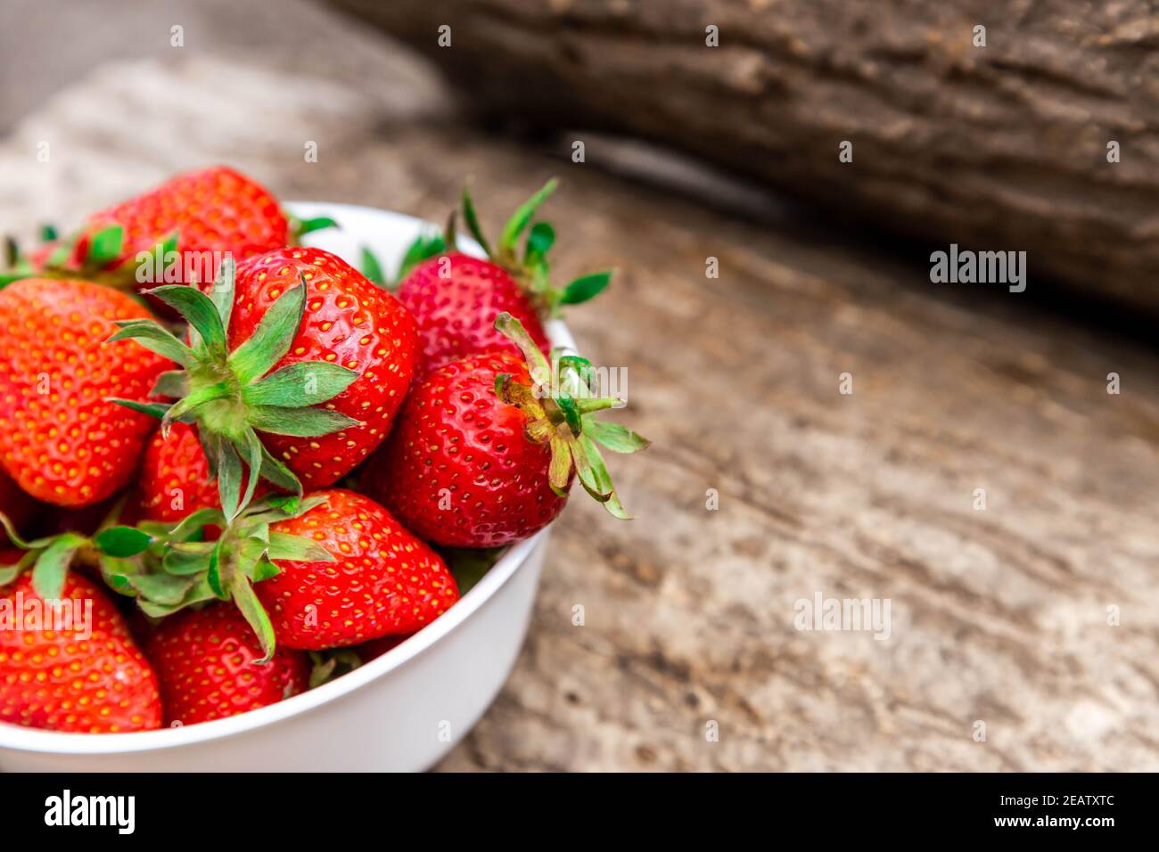 wooden bowl full of fresh strawberries on the brown table Stock Photo ...