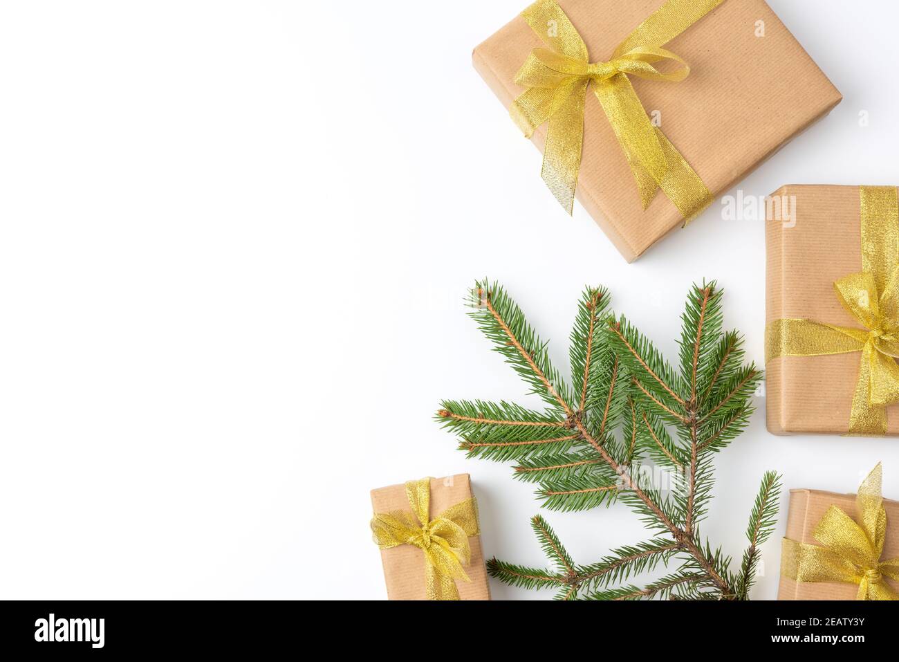 gift boxes wrapped in brown paper and tied with a golden ribbon on a white background Stock Photo