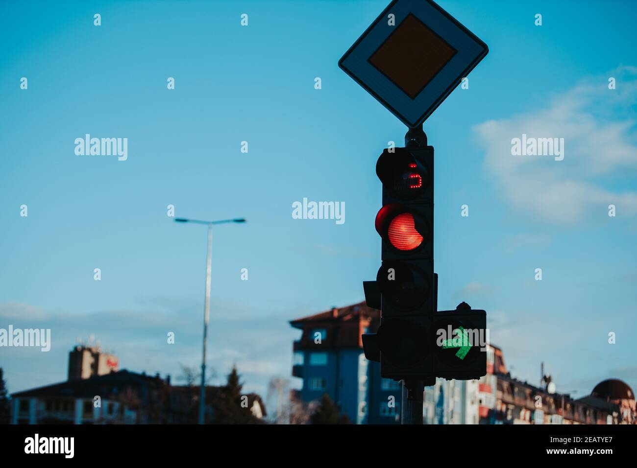 Main road sign and a traffic light on blue sky background Stock Photo ...