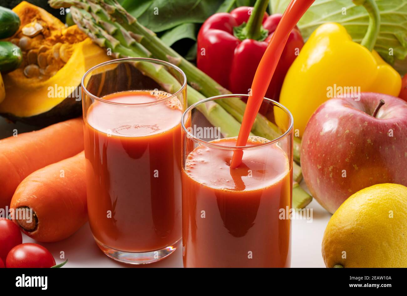A lot of different kinds of vegetables and fruits on a white background and a glass of vegetable juice Stock Photo