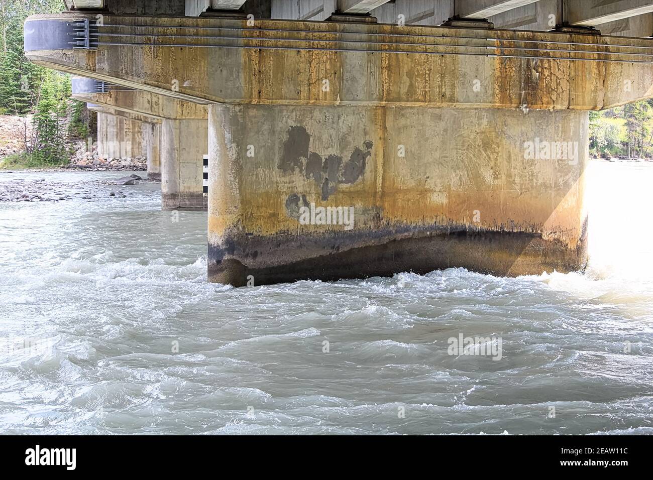 Water flowing fast under a concrete bridge Stock Photo