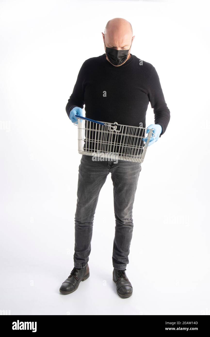 Man with mouth protection and hand gloves looking in his shopping basket, isolated on white background Stock Photo