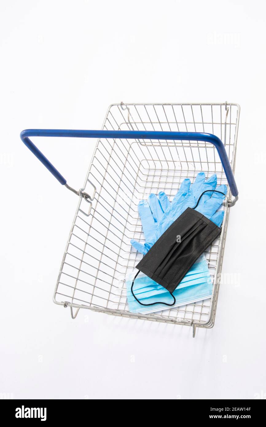 Shopping basket with mouth protection and hand gloves, isolated on white background Stock Photo