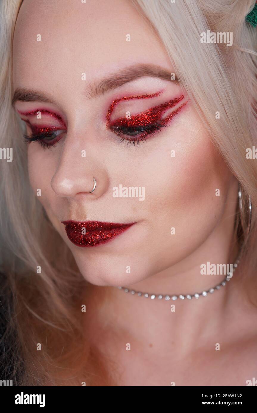 young blond woman with red glitter makeup Stock Photo Alamy