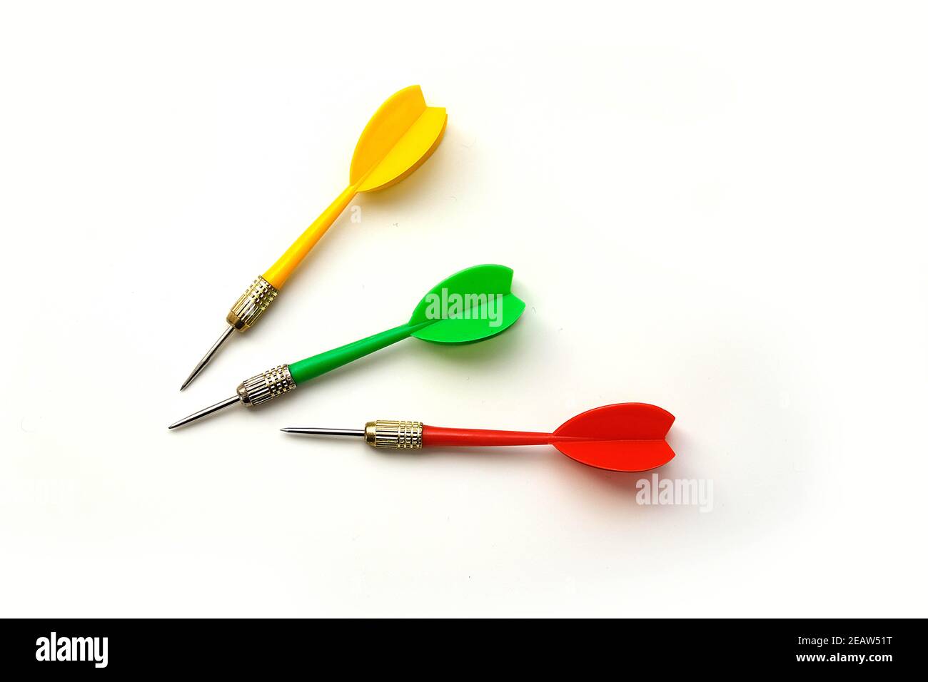 Yellow, green and red darts on a white background, close-up Stock Photo
