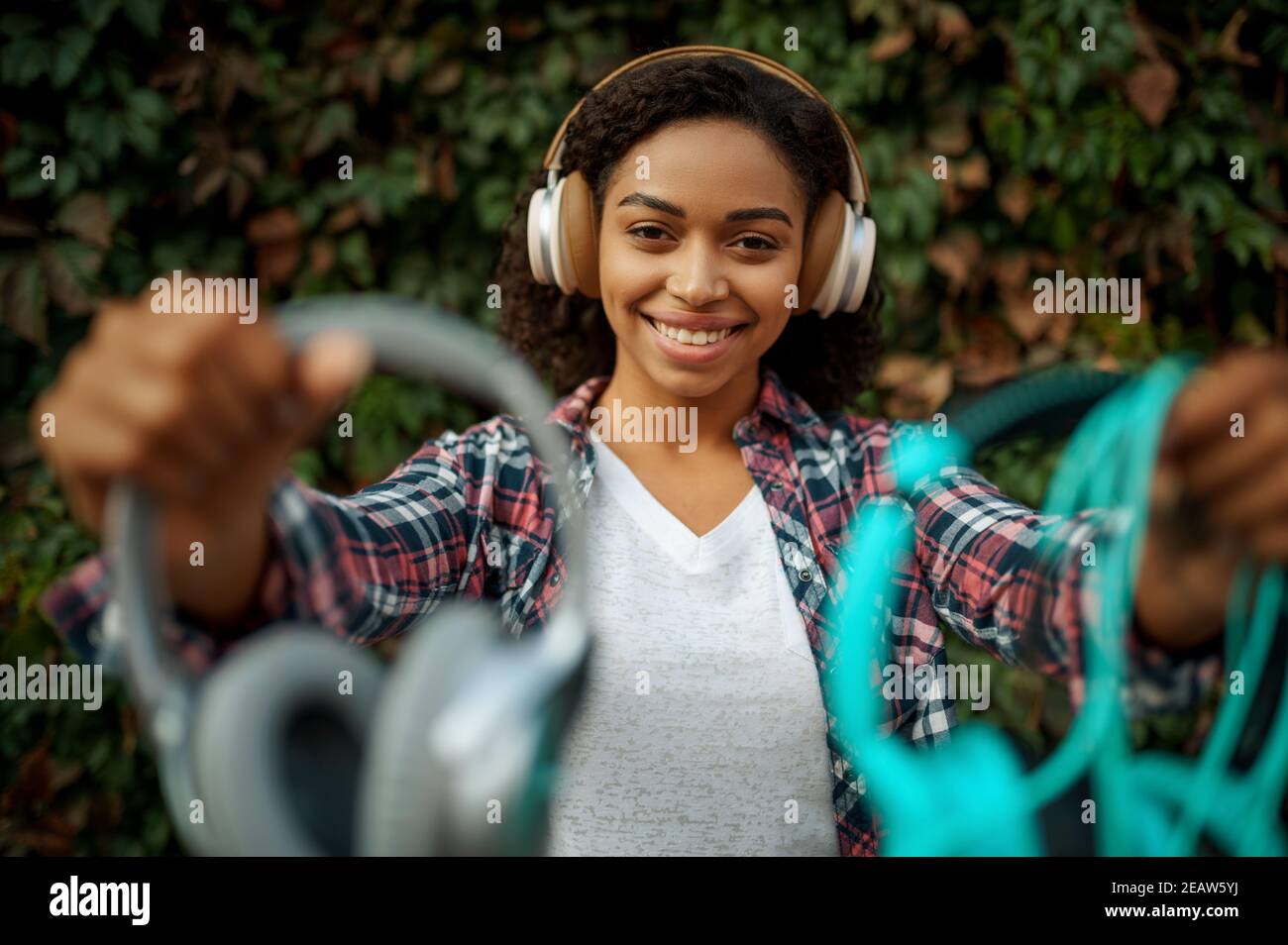 Music fan in headphones listening to music in park Stock Photo