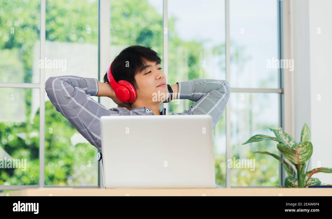 business man smile listening music in red headphone at home office Stock Photo