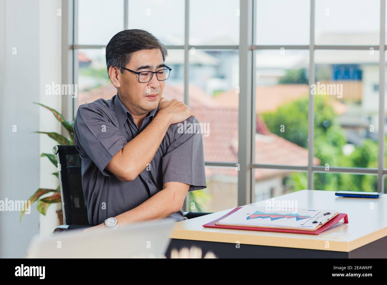 businessman working with laptop computer has a problem with shoulder pain Stock Photo