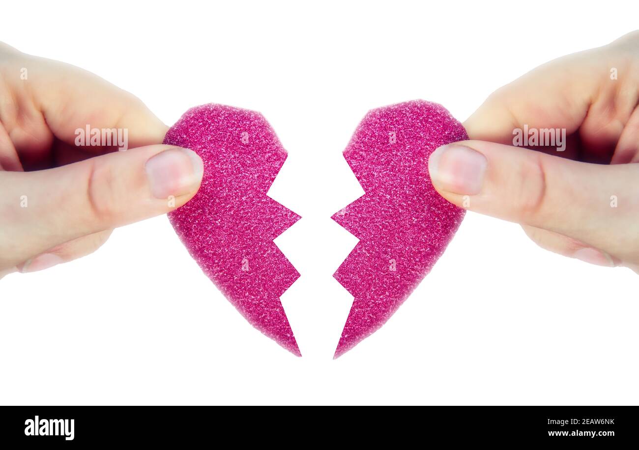 Two hands holding two halves broken pink heart into two parts together isolated on white background, romantic,dating, Valentine's day concept Stock Photo