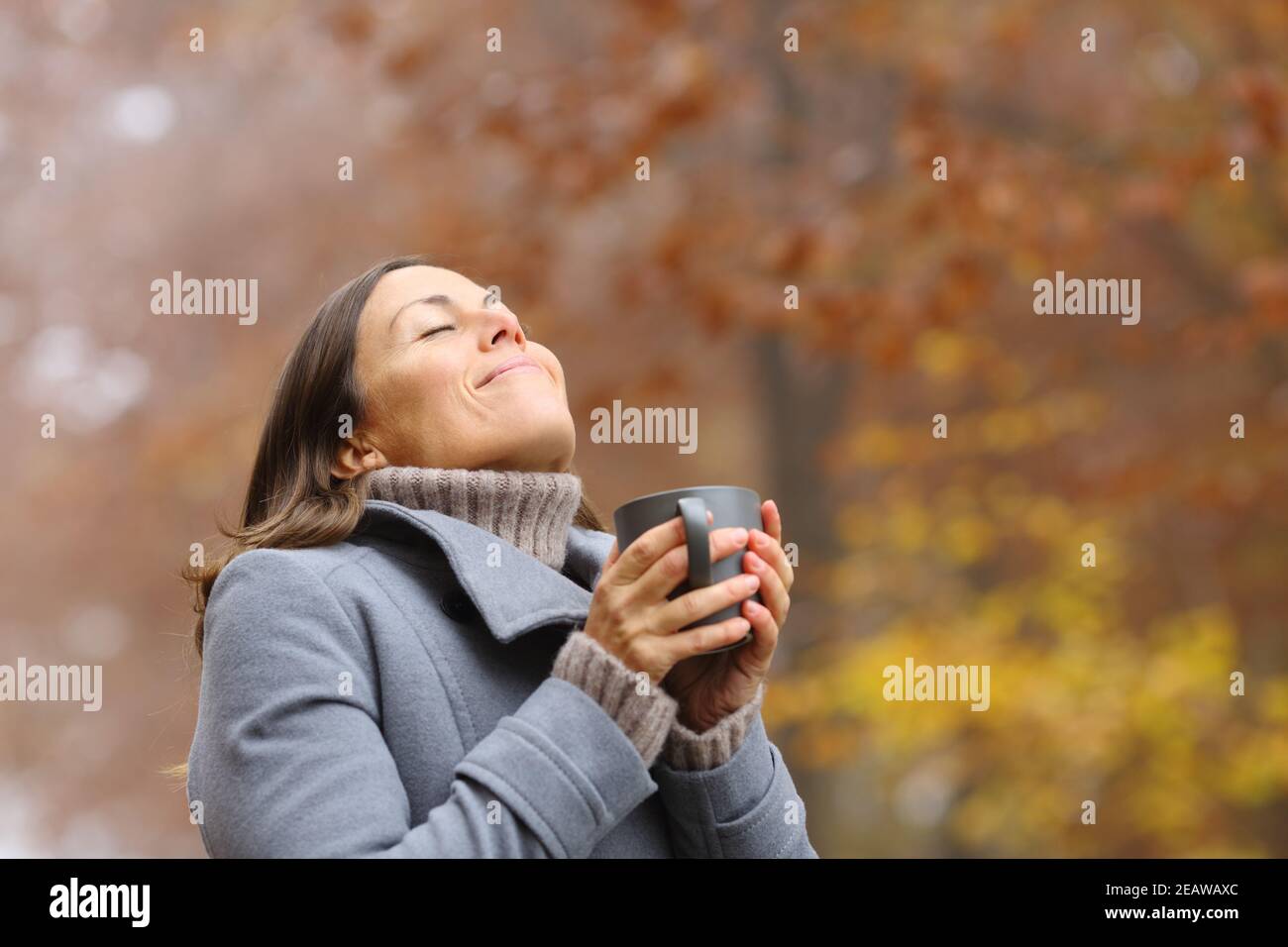 Happy middle age woman breathing at breakfast in a park Stock Photo