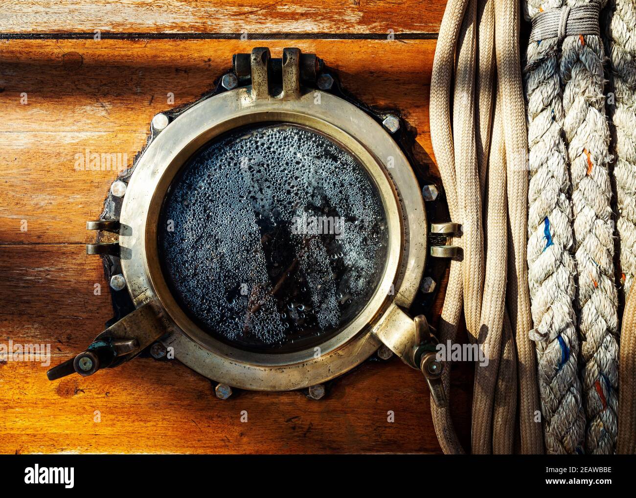 Vintage ship brass porthole and ropes Stock Photo